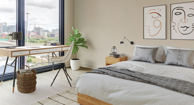 Spacious bedroom featuring a wooden desk by a large window with cityscape views, and minimalist decor at Westerly, Chicago