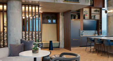 Stylish communal kitchen and lounge area with bar seating, comfortable sofas, and modern design elements at Westerly, Chicago