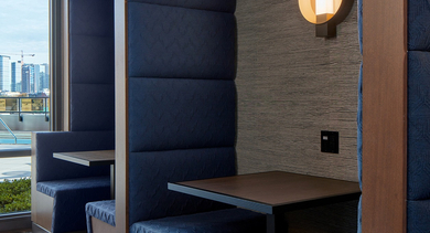 Modern coworking booths with comfortable seating and a view of the Chicago skyline and pool area at Westerly apartments