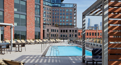 Expansive outdoor pool deck with lounge chairs, shaded pergolas, and views of the surrounding Chicago architecture at Westerly