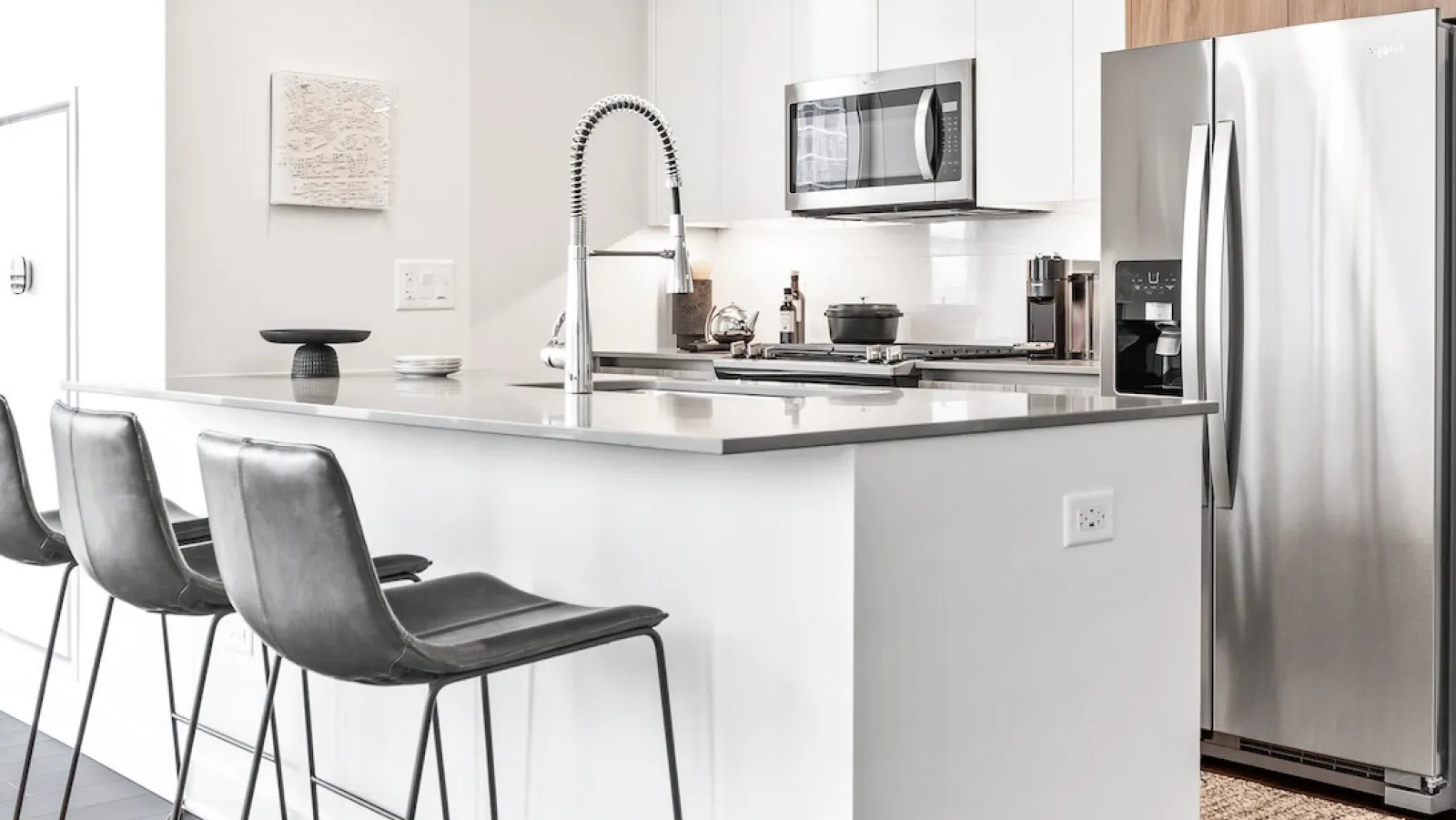 Contemporary kitchen with a large island, bar stools, and a view of the city skyline at Wolf Point East apartments in Chicago