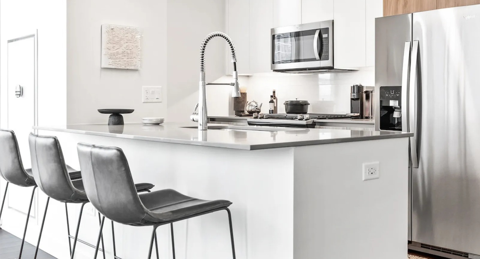 Contemporary kitchen with a large island, bar stools, and a view of the city skyline at Wolf Point East apartments in Chicago