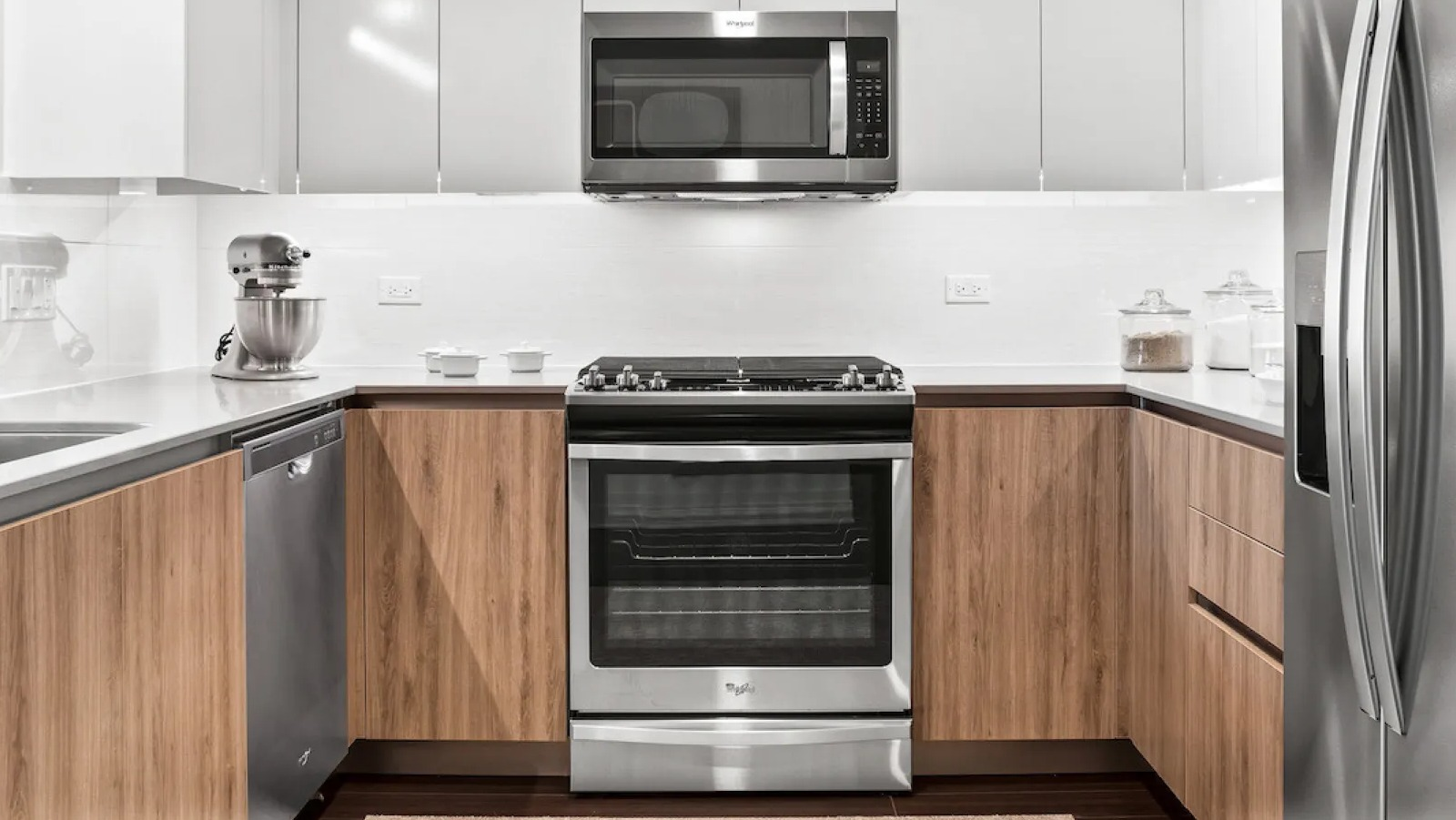 Modern kitchen featuring stainless steel appliances, light wood cabinetry, and a warm rug at Wolf Point East apartments in Chicago
