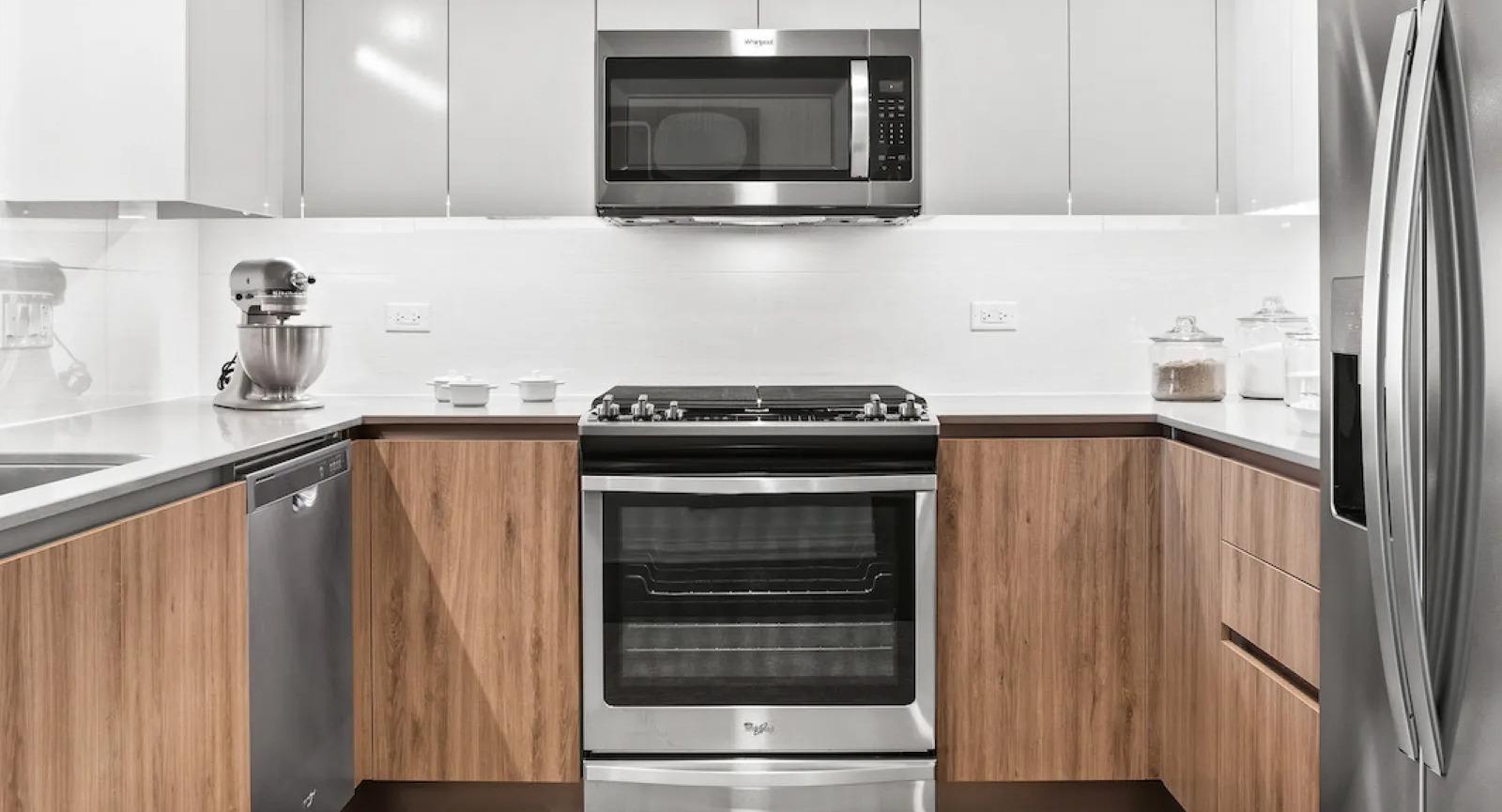 Modern kitchen featuring stainless steel appliances, light wood cabinetry, and a warm rug at Wolf Point East apartments in Chicago