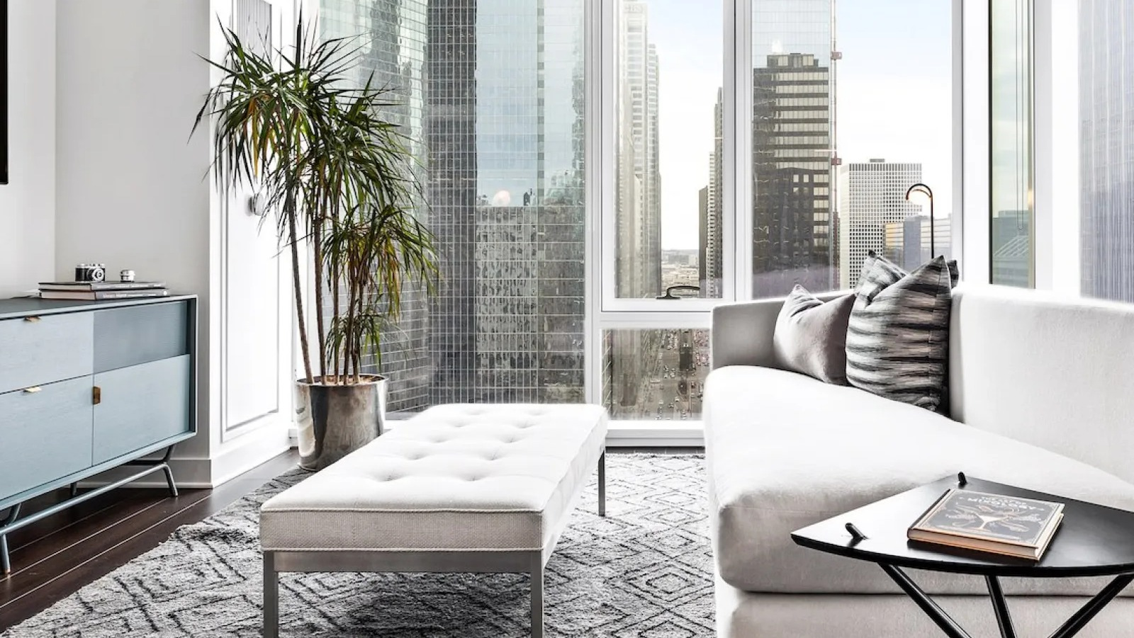 Bright, modern living room with large windows showcasing city views and comfortable seating at Wolf Point East in Chicago