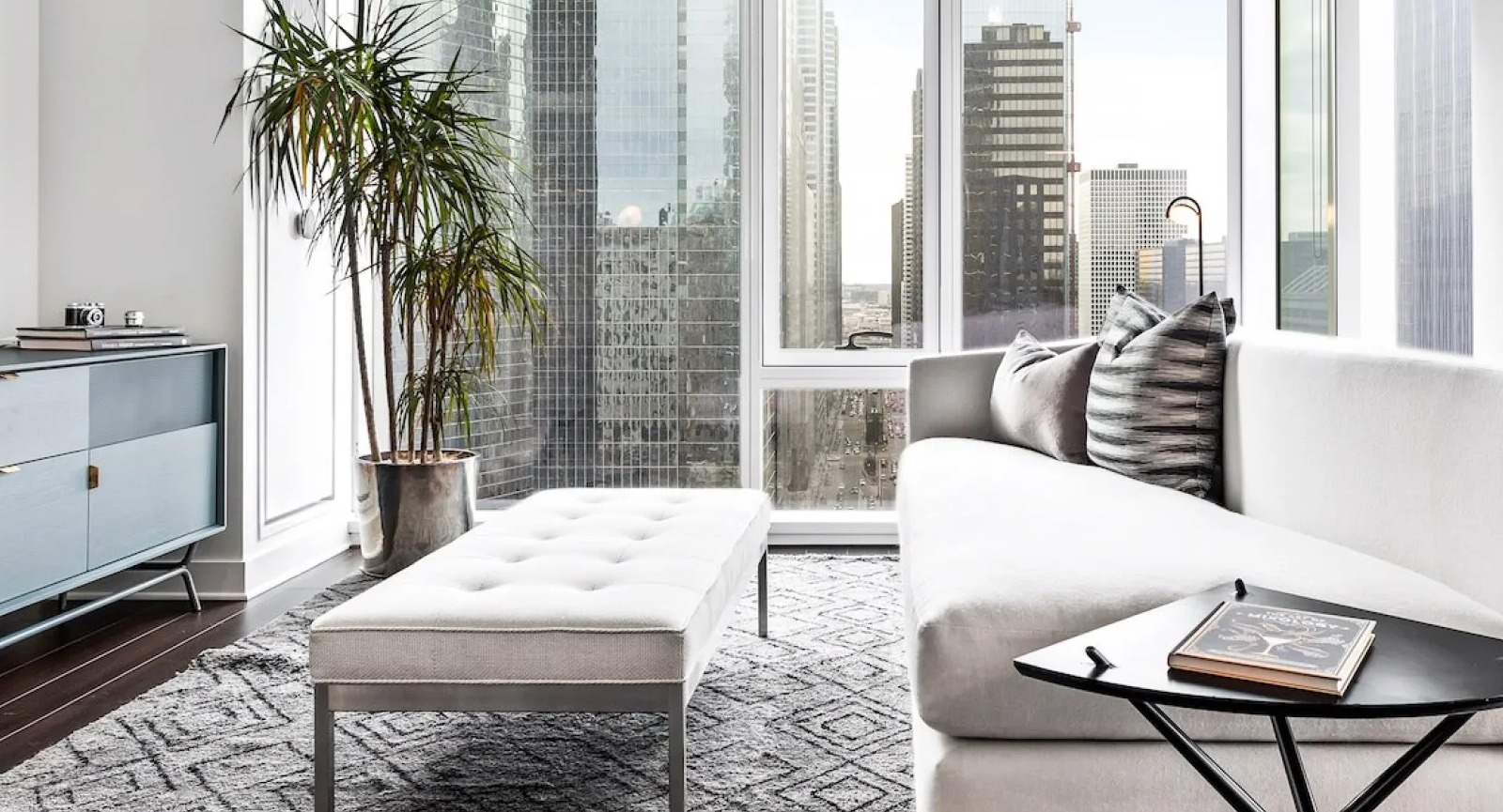 Bright, modern living room with large windows showcasing city views and comfortable seating at Wolf Point East in Chicago