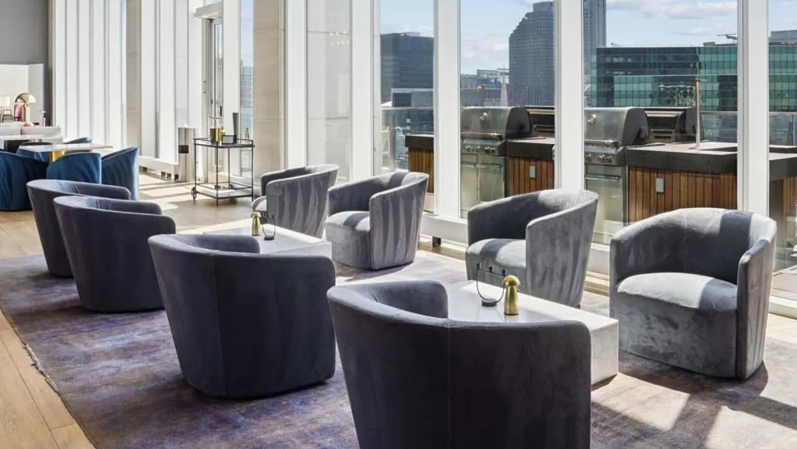 Expansive outdoor terrace with comfortable lounge chairs and grills, offering stunning city views at Wolf Point East in Chicago