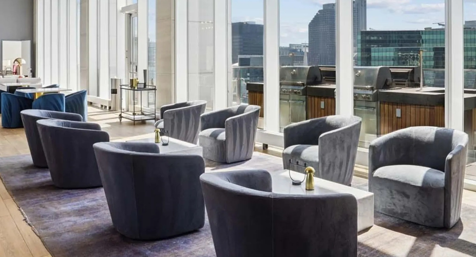Expansive outdoor terrace with comfortable lounge chairs and grills, offering stunning city views at Wolf Point East in Chicago