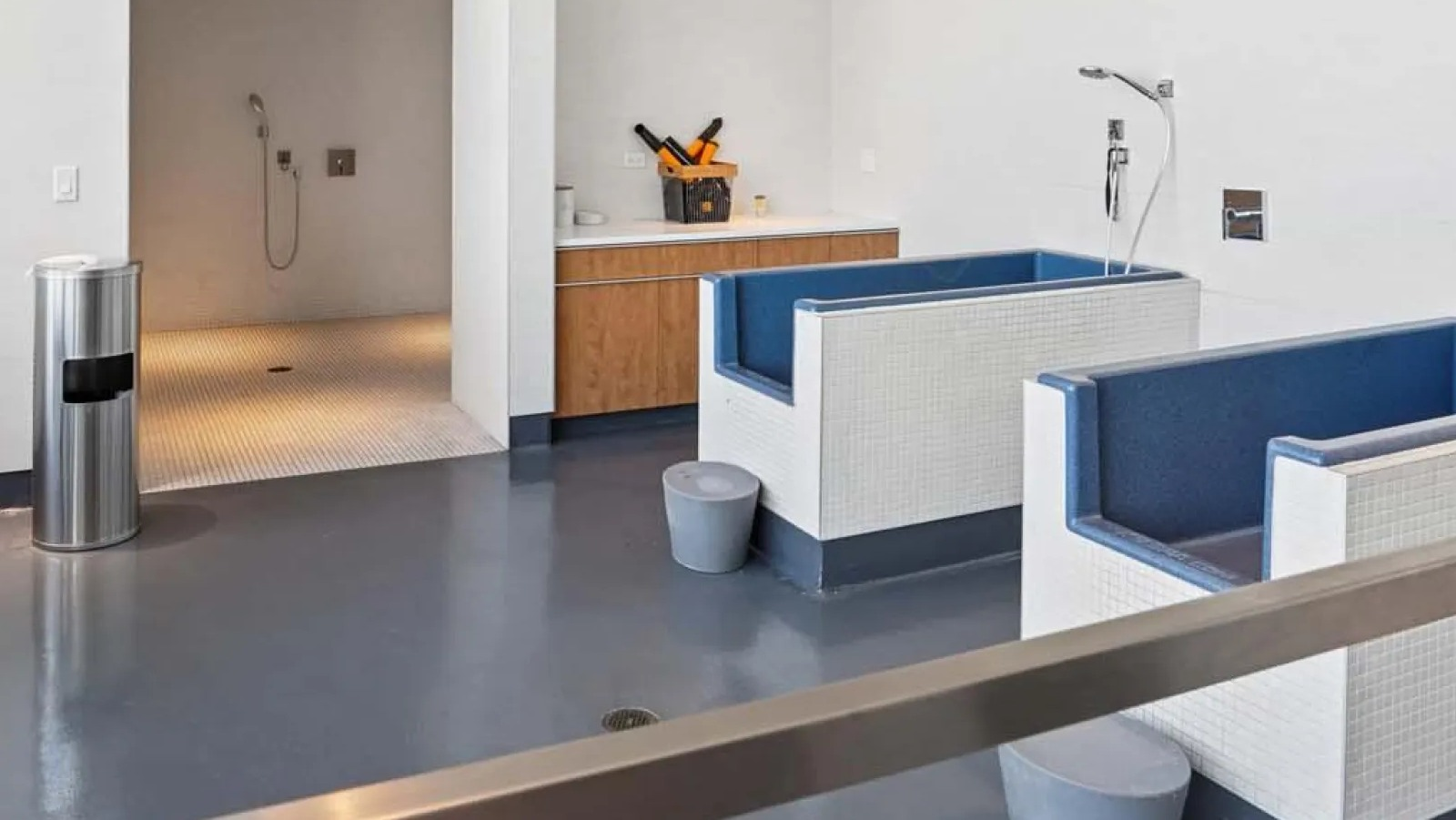 Dedicated pet spa with multiple washing stations, grooming tables, and a shower area at Wolf Point East apartments in Chicago