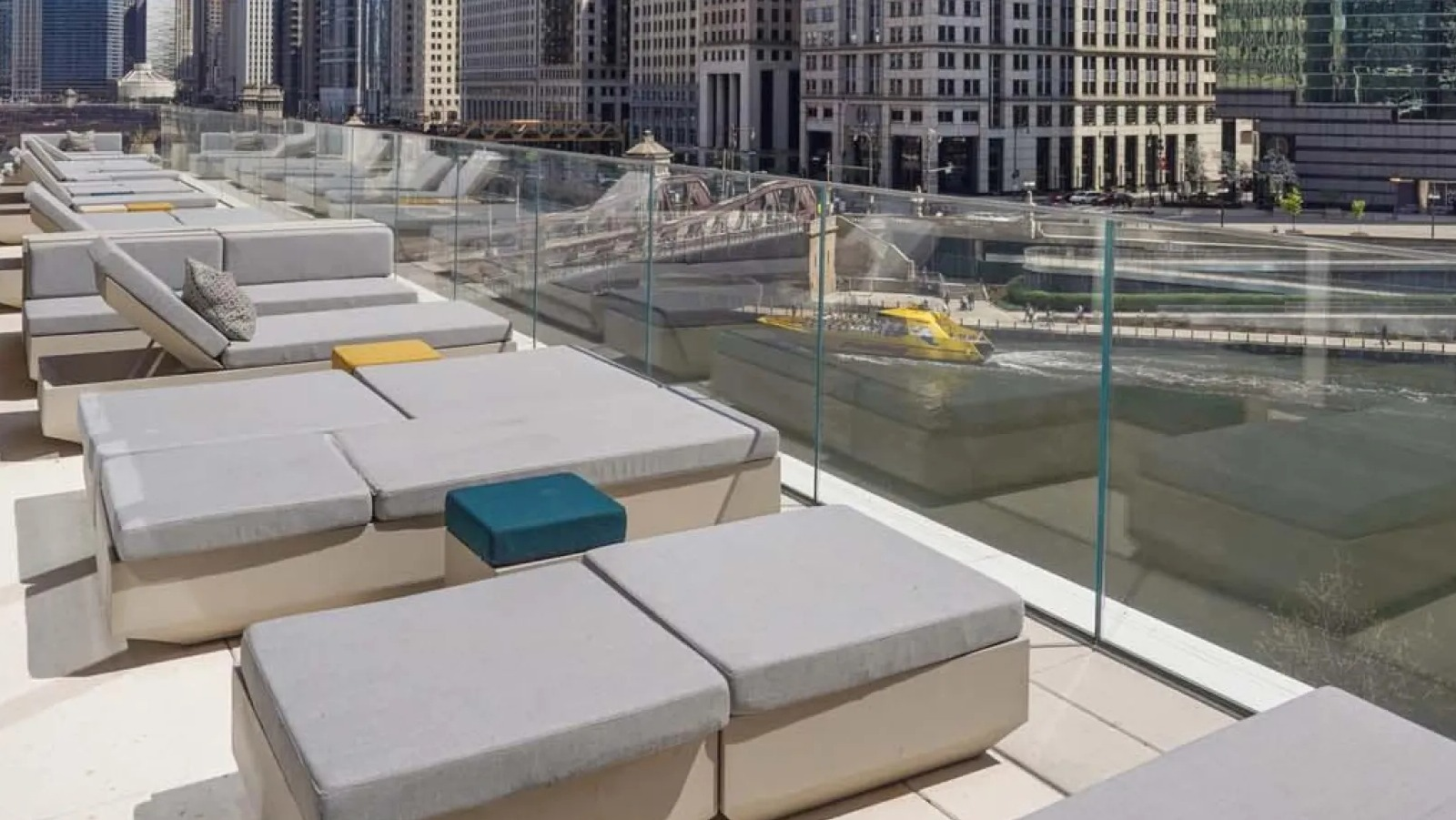 Luxurious riverfront sun deck with lounge seating, offering stunning views of the Chicago River and city skyline