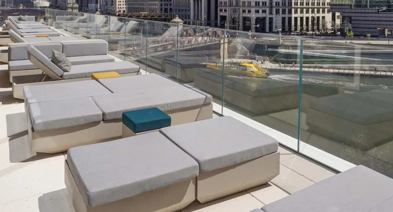 Luxurious riverfront sun deck with lounge seating, offering stunning views of the Chicago River and city skyline