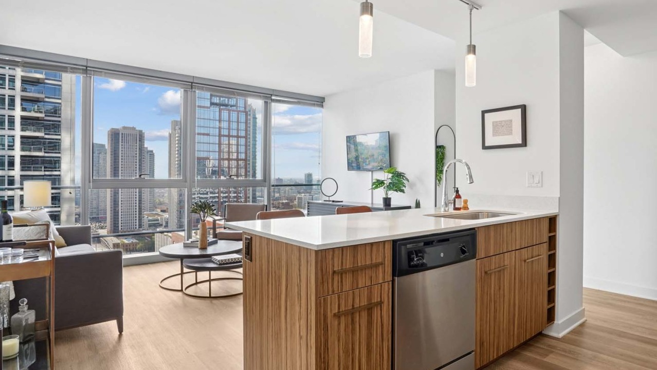 Spacious living room at Wolf Point West apartments in Chicago with floor-to-ceiling windows and city skyline views