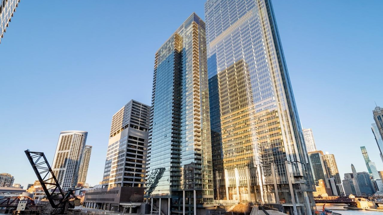 Exterior view of Wolf Point West apartment tower in Chicago with glass facade and stunning riverfront location
