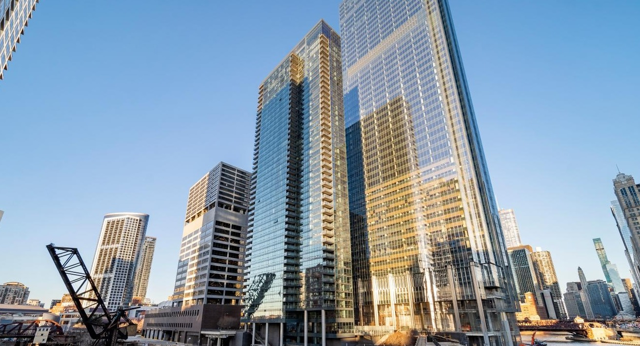 Exterior view of Wolf Point West apartment tower in Chicago with glass facade and stunning riverfront location
