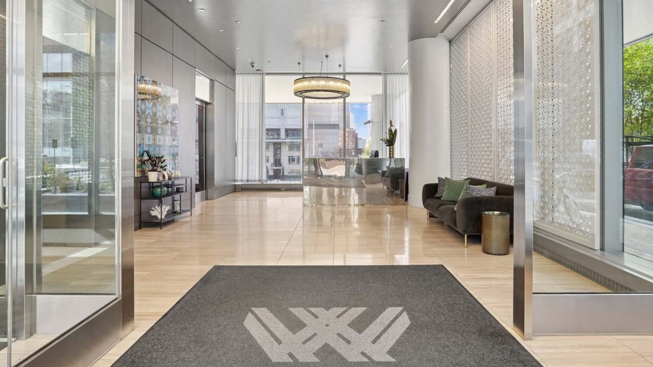 Elegant lobby at Wolf Point West apartments in Chicago featuring modern seating, chandelier lighting, and large windows