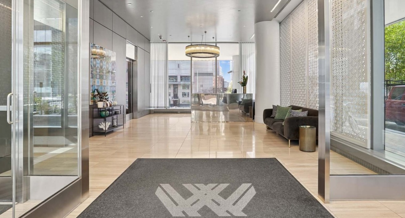 Elegant lobby at Wolf Point West apartments in Chicago featuring modern seating, chandelier lighting, and large windows