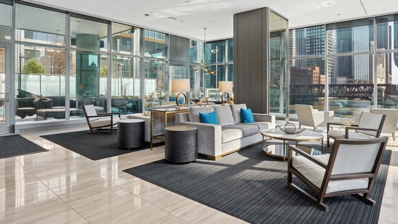 Spacious lounge at Wolf Point West apartments in Chicago with modern seating, natural light, and Chicago River views