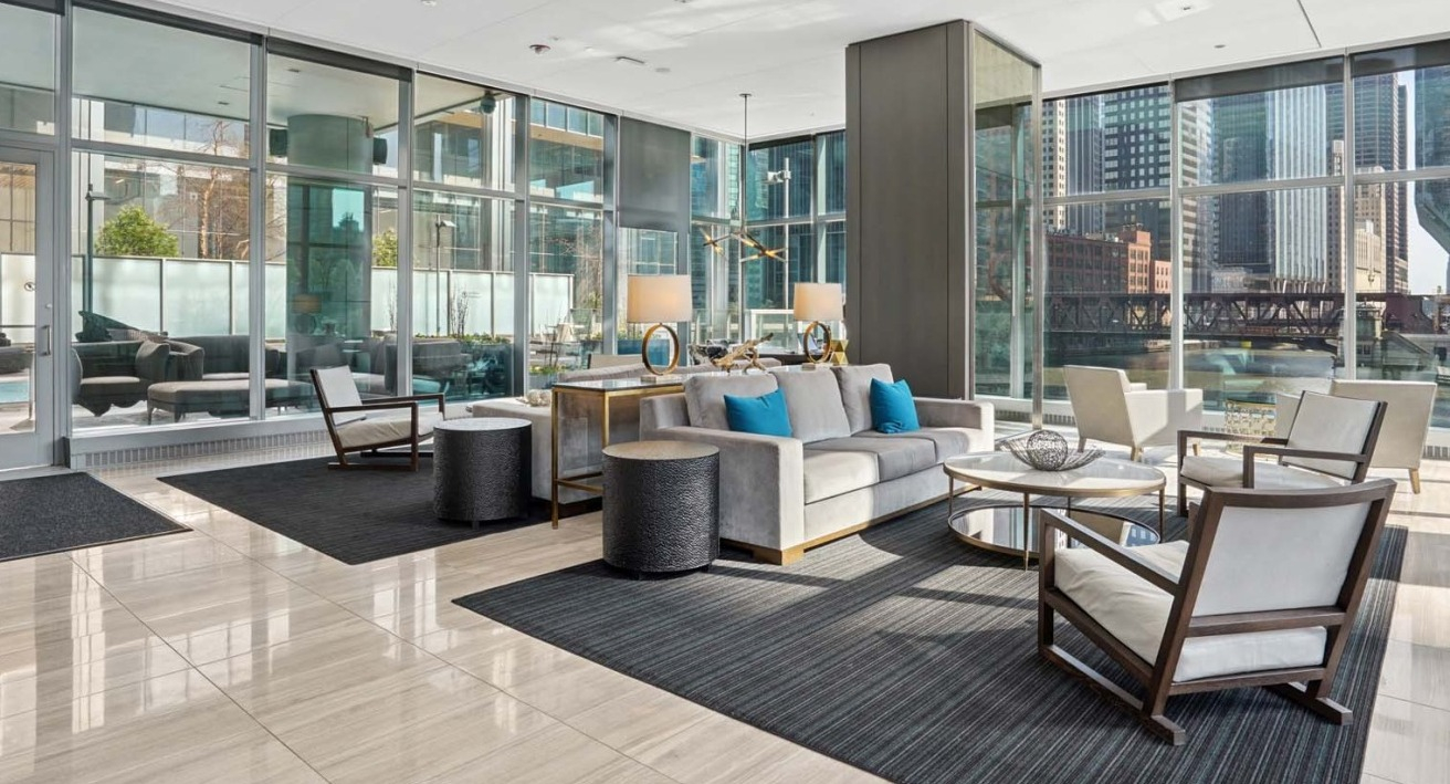 Spacious lounge at Wolf Point West apartments in Chicago with modern seating, natural light, and Chicago River views