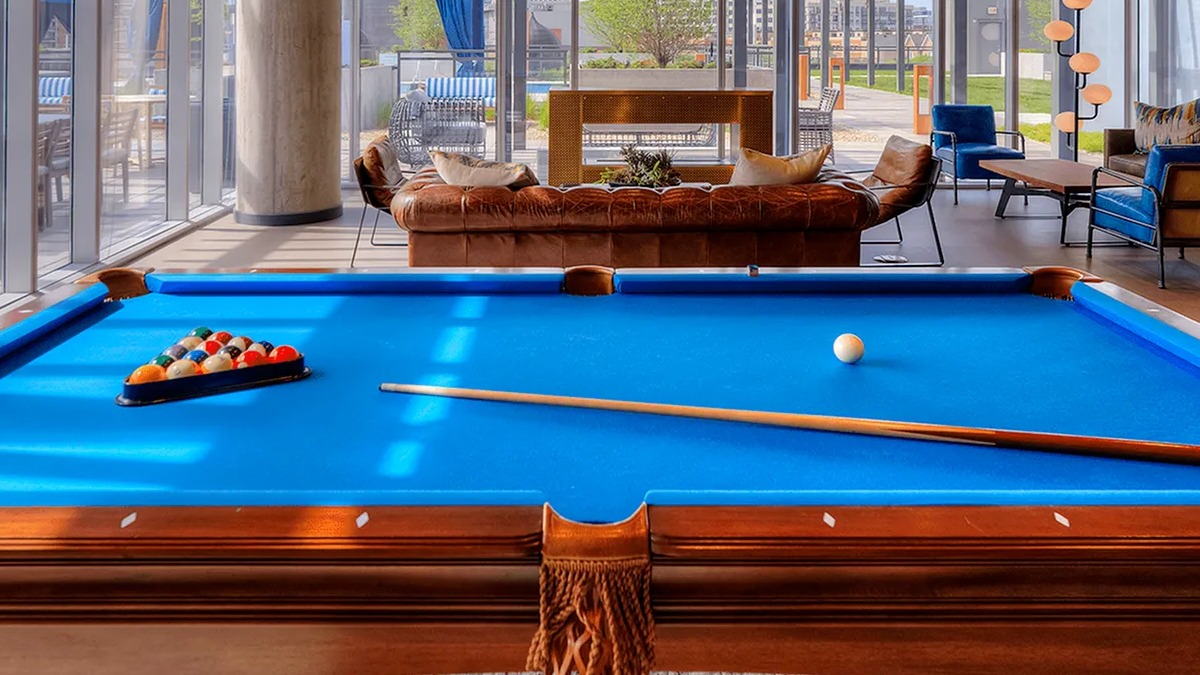 Entertainment room featuring a billiards table, comfortable lounge seating, and city views at Xavier Apartments in Chicago