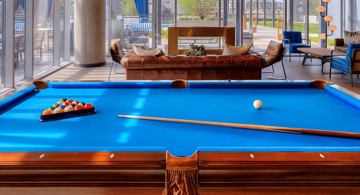 Entertainment room featuring a billiards table, comfortable lounge seating, and city views at Xavier Apartments in Chicago