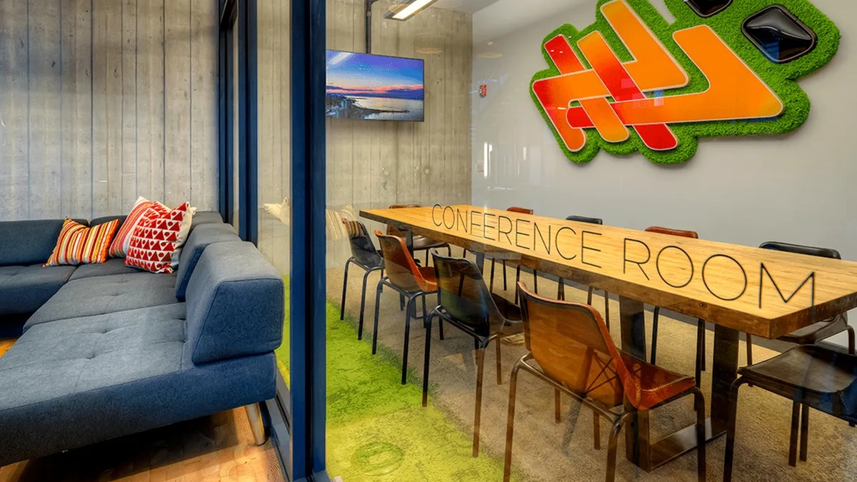 Modern conference room with a large table, comfortable lounge seating, and a TV at Xavier Apartments in Chicago