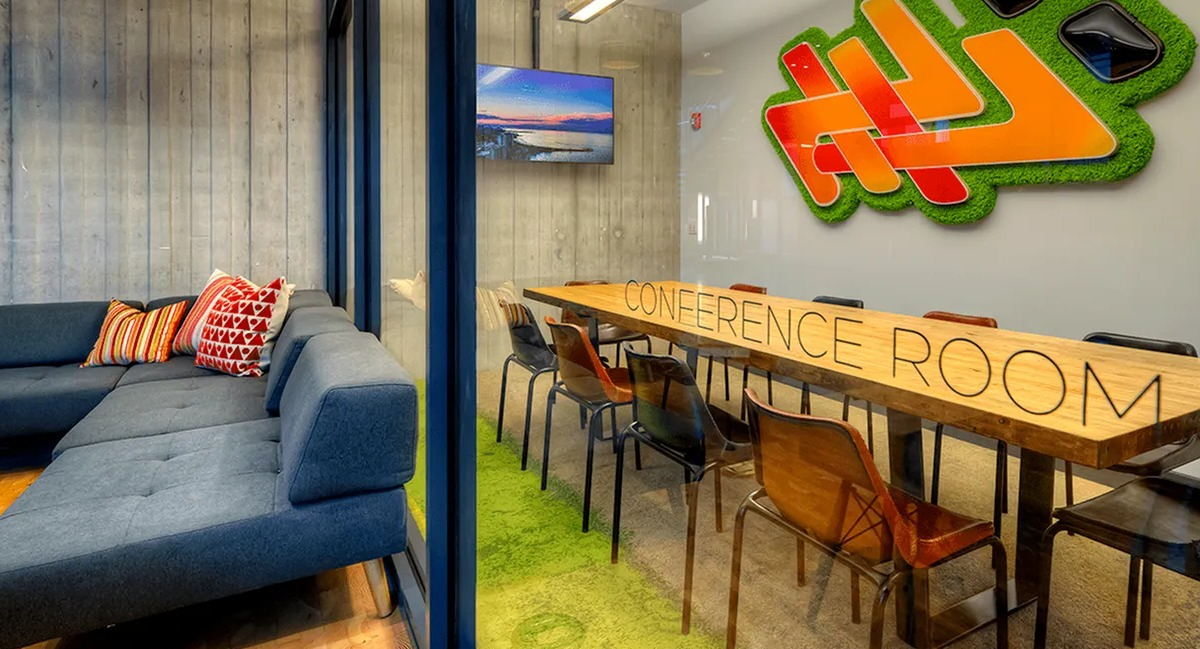Modern conference room with a large table, comfortable lounge seating, and a TV at Xavier Apartments in Chicago