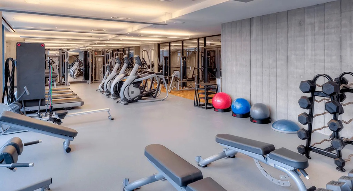 Spacious gym with various weightlifting equipment, free weights, and cardio machines at Xavier Apartments in Chicago