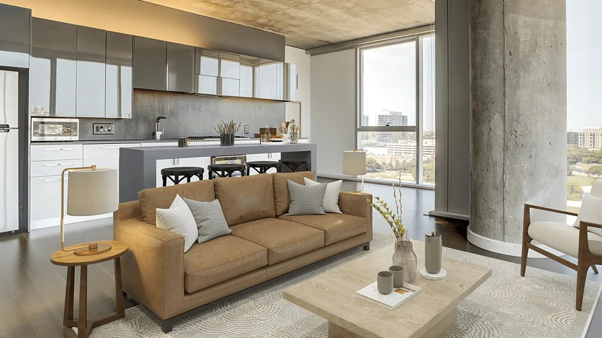 Spacious open-concept kitchen and lounge area with a tan sofa, island seating, and large windows at Xavier Apartments in Chicago