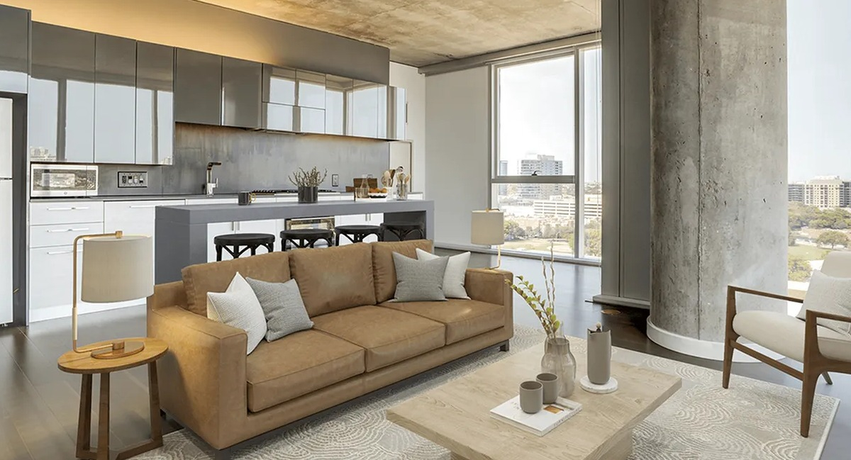 Spacious open-concept kitchen and lounge area with a tan sofa, island seating, and large windows at Xavier Apartments in Chicago